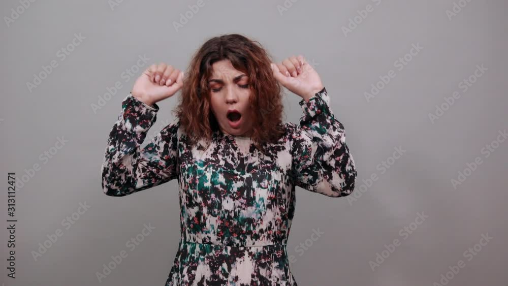 Attractive tired caucasian young woman covered mouth with hand, yawning over isolated gray background in fashion shirt. Lifestyle concept Attractive tired caucasian young woman covered mouth with hand, yawning over isolated gray background in fashion shirt. Lifestyle concept