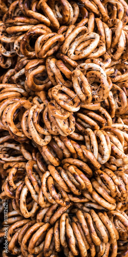 Tasty bagels with poppy on rope at the market stall © Roberto Sorin