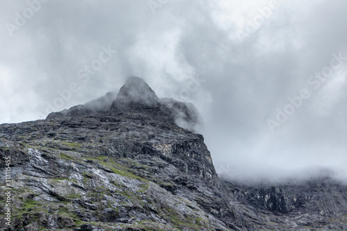 Mountain peak covered with thick clouds blanket view on Trolls Path Trollstigen road in Norway Europe