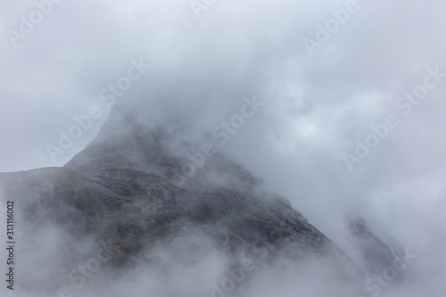 Mountain peak covered with thick clouds blanket view on Trolls Path Trollstigen road in Norway Europe