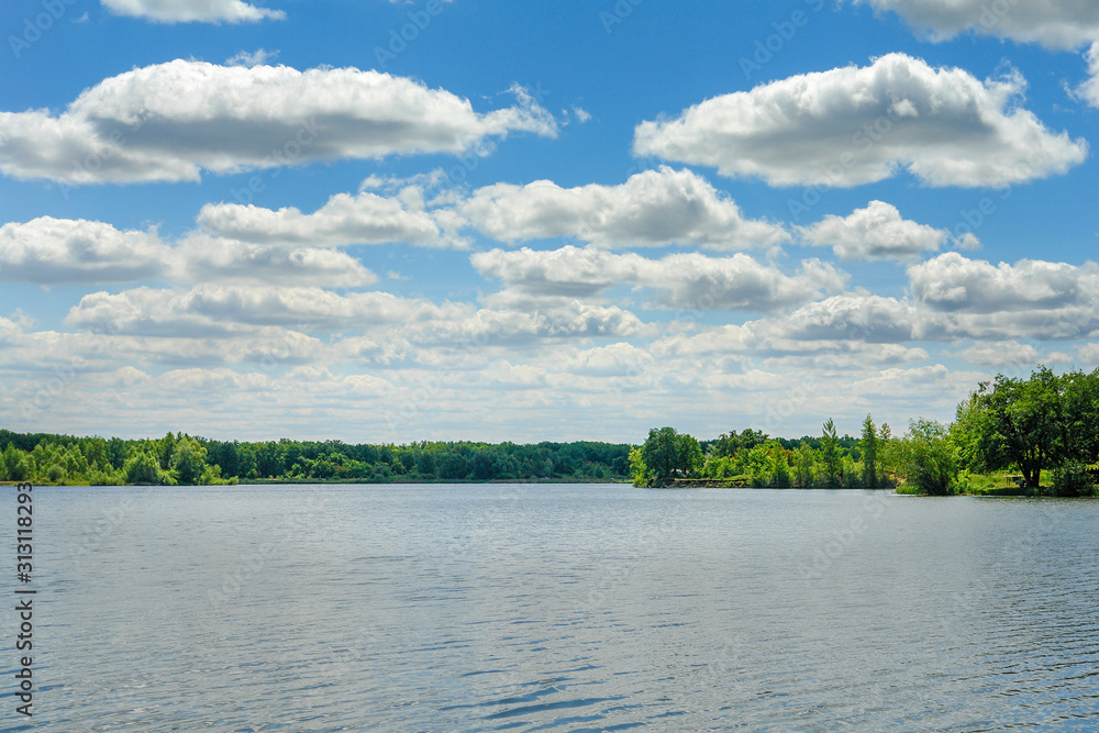 Obraz premium The blue sky with the clouds above the clear blue lake