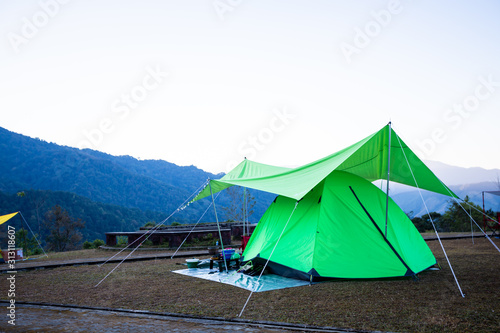 Camping green tent in mountain sunrise morning