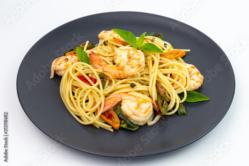 Spaghetti with spicy fried shrimp on a white background