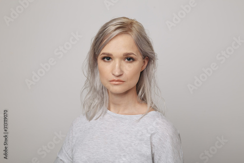 Portrait of young woman with cute face posing in the white studio isolated