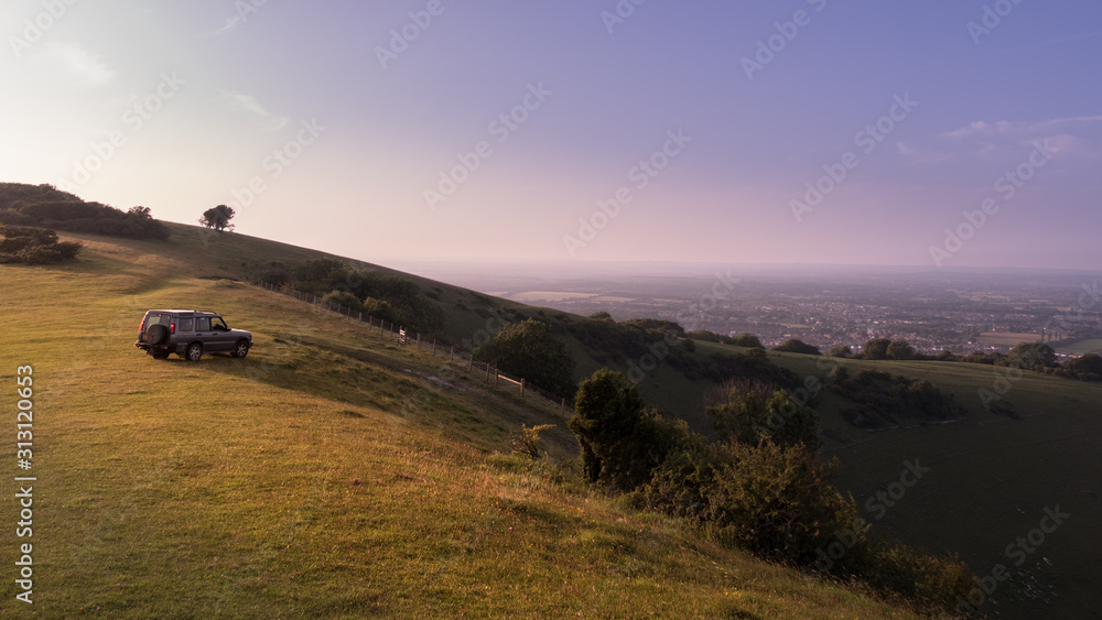Obraz premium Car parked on a hill in East Sussex with layers of mist viewed from Butts Brow in the South Downs National Park