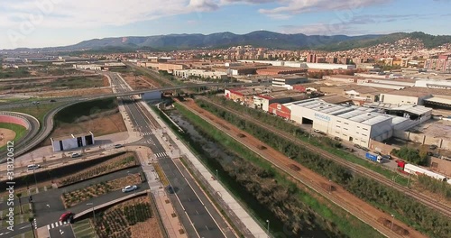 Aerial view over commercial area in the suburbs of Barcelona, Spain, showing distinct urban zones such as malls, industrial sites, suburban residential buildings, and bypass highway