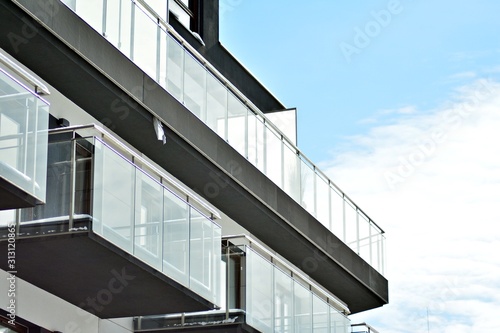 Contemporary residential building exterior in the daylight. Modern apartment buildings on a sunny day with a blue sky. Facade of a modern apartment building © Grand Warszawski