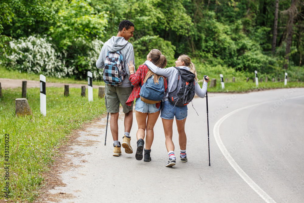Group of friends hiking in nature.They walking by the old country road. Group of friends hiking in nature.They walking by the old country road.