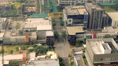 Slow aerial view of the highly urbanized city of Manila, Philipines, showing buildings, roads and constructions in development during the day