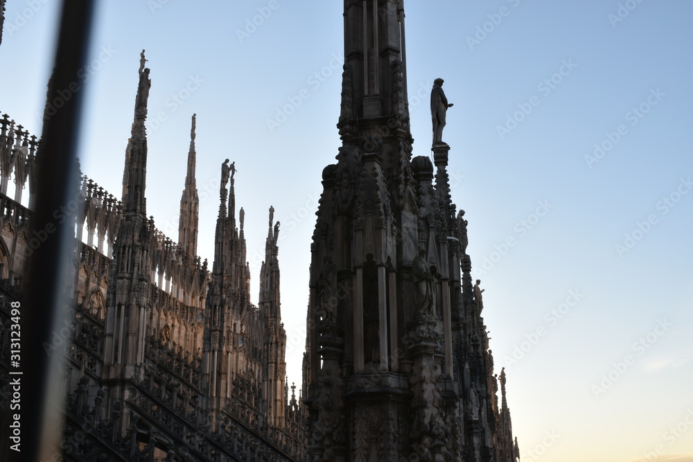 Pillars of milan cathedral and sunset in background