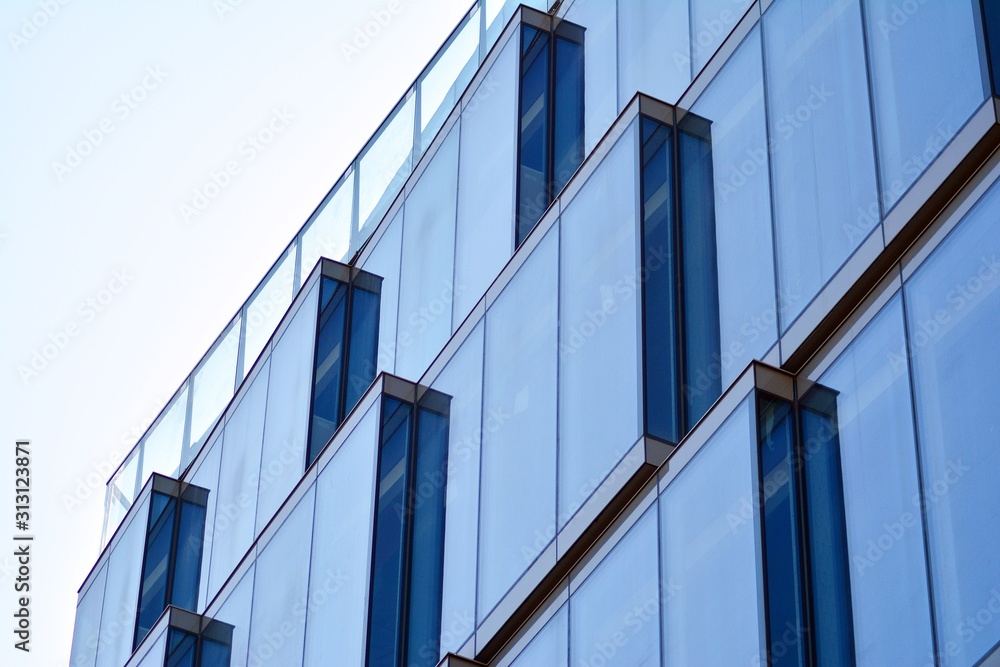 Fototapeta premium Na zewnątrz współczesnego budynku mieszkalnego w świetle dziennym. Nowoczesne budynki mieszkalne w słoneczny dzień z błękitnym niebem. Fasada nowoczesnego apartamentowca