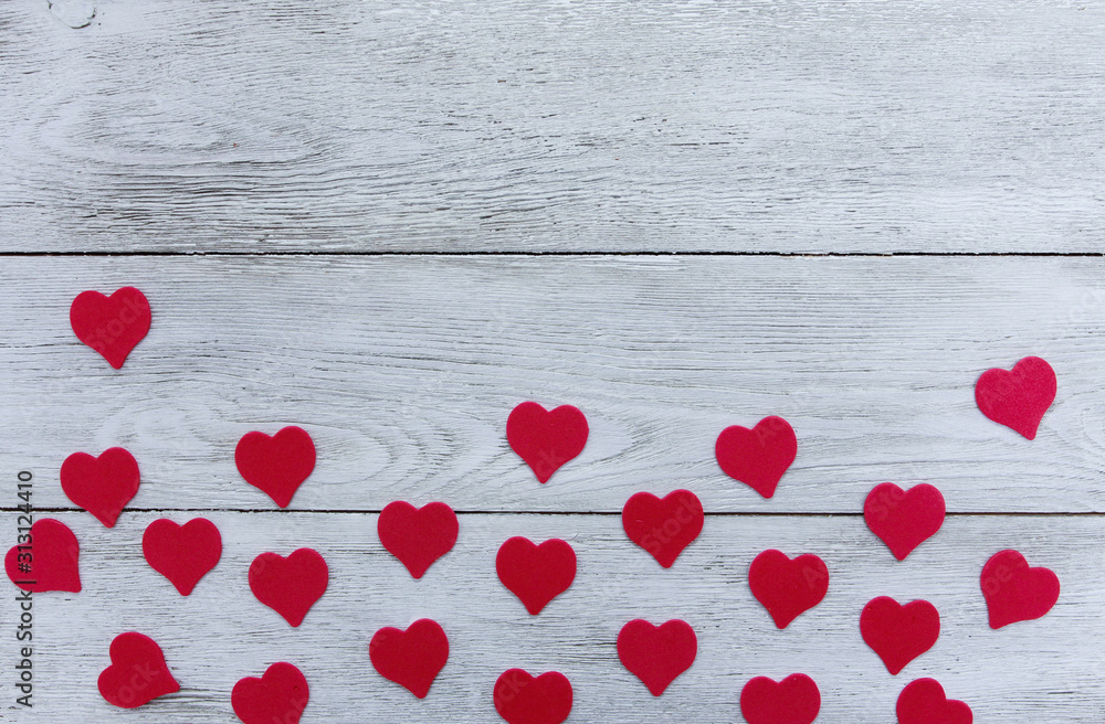 Red hearts scattered on white wooden boards. Valentines day concept. Border, copy space Red hearts scattered on white wooden boards. Valentines day concept. Border, copy space