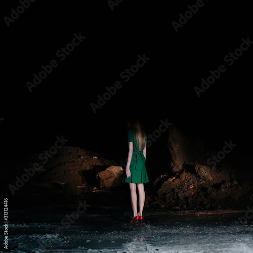 Girl with green dress alone on dark road photo