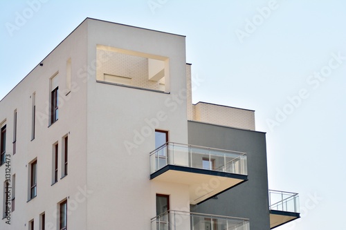 Contemporary residential building exterior in the daylight. Modern apartment buildings on a sunny day with a blue sky. Facade of a modern apartment building