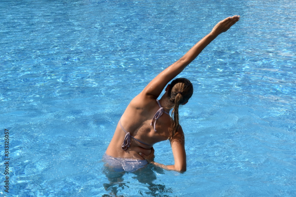Exercises in the pool. Girl doing exercises in the pool. an active sport. beautiful woman in swimsuit in water training