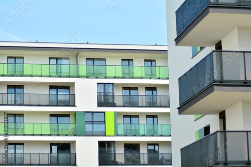 Contemporary residential building exterior in the daylight. Modern apartment buildings on a sunny day with a blue sky. Facade of a modern apartment building