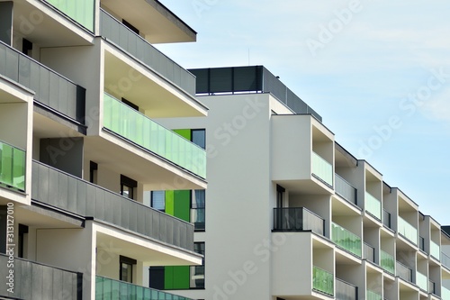 Contemporary residential building exterior in the daylight. Modern apartment buildings on a sunny day with a blue sky. Facade of a modern apartment building