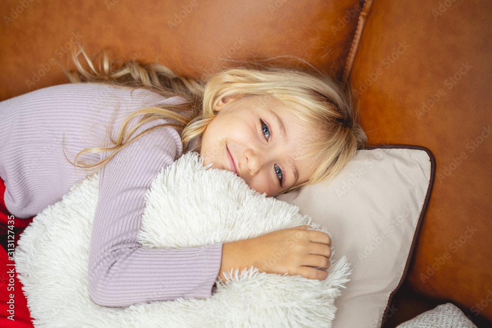 Adorable little girl lying on couch at home Adorable little girl lying on couch at home