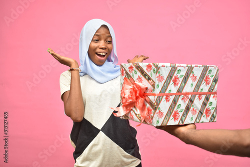 Fotografija pretty young black woman feeling excited while getting a gift from someone