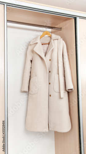 White female coat on hangers in the closet