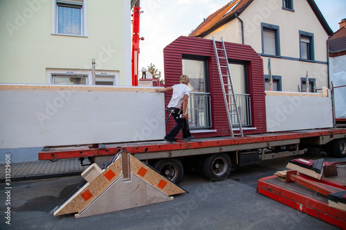 Wallpaper Mural Bauteil eines Fertighause mit großen Fenstern auf Tieflader mit Monteur und Leiter Torontodigital.ca