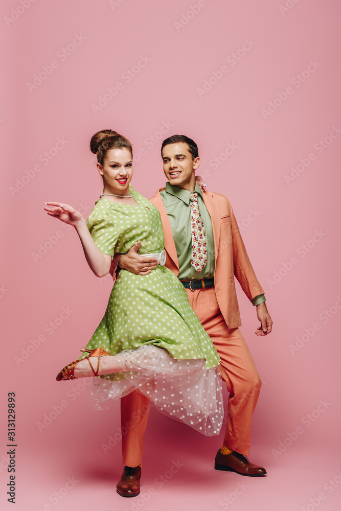 handsome dancer hugging girl while dancing boogie-woogie on pink background handsome dancer hugging girl while dancing boogie-woogie on pink background