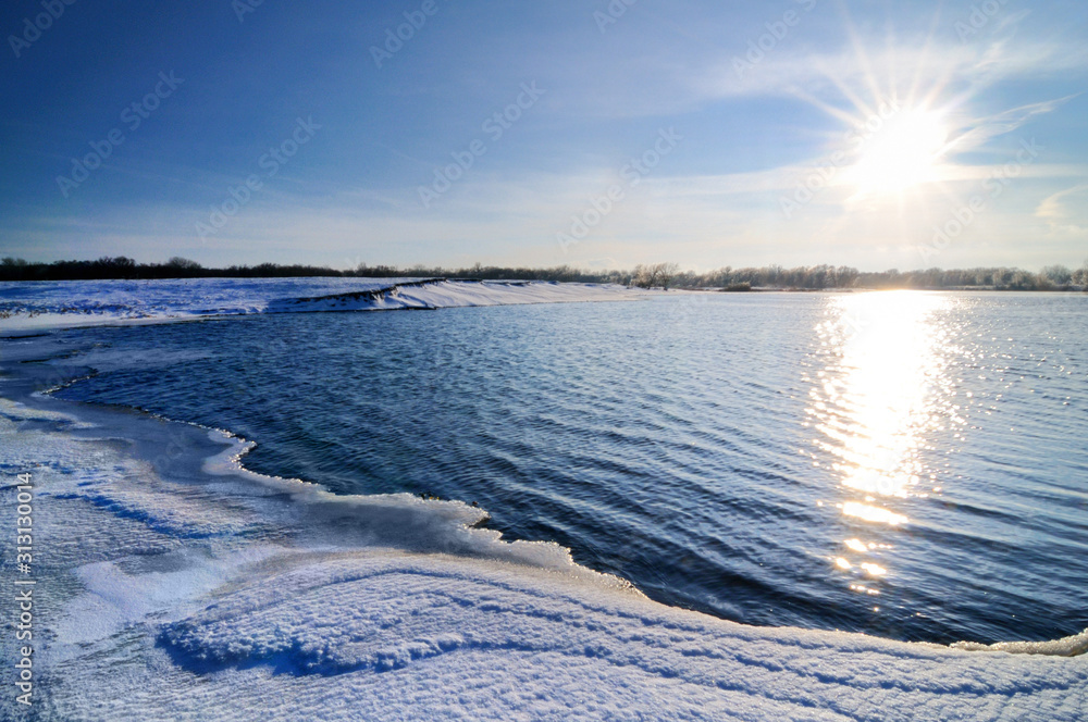 Winter landscape, lake shore covered with snow