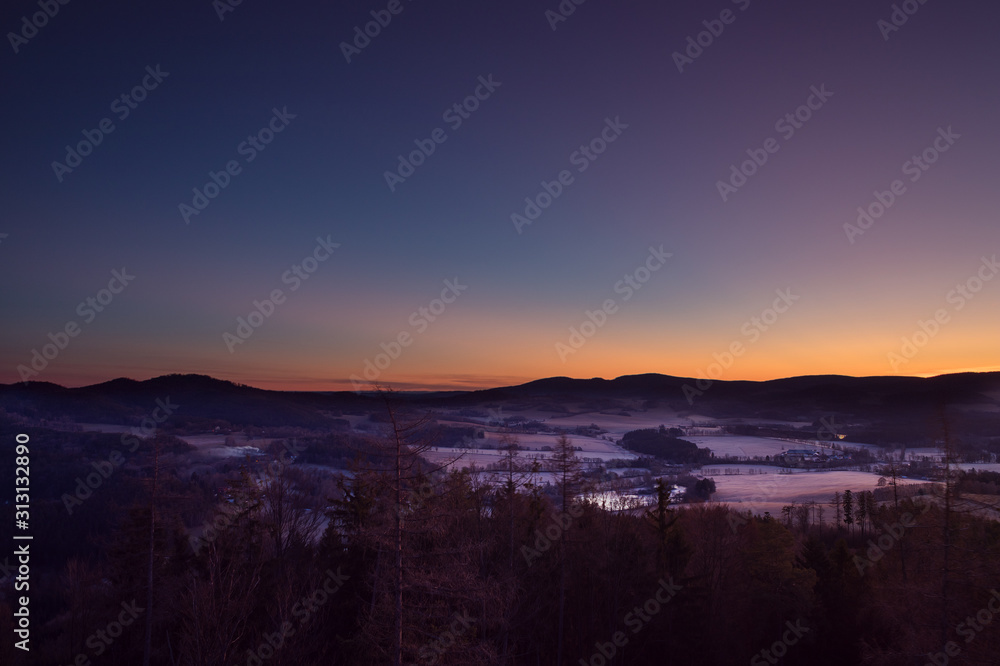 sunrise over winter landscape in the mountains, blue and red sky