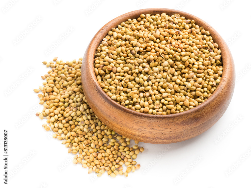 Spice coriander (Coriandrum sativum) seeds in wooden bowl isolated on white background. Indian cuisine, ayurveda, naturopathy concept Spice coriander (Coriandrum sativum) seeds in wooden bowl isolated on white background. Indian cuisine, ayurveda, naturopathy concept