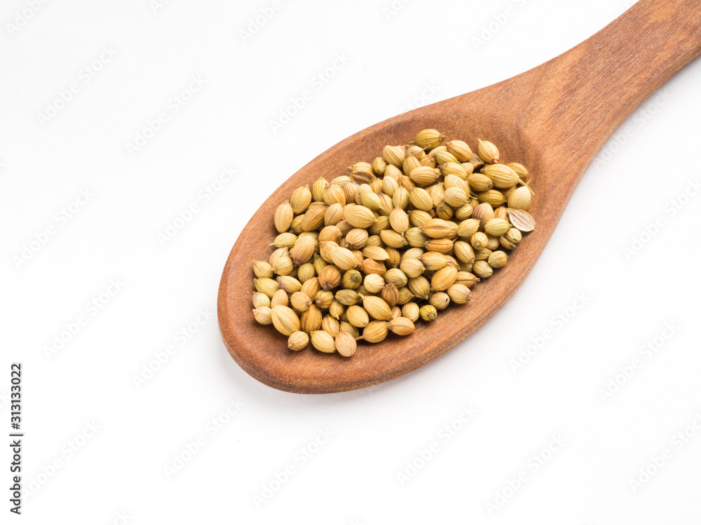 Spice coriander (Coriandrum sativum) seeds in wooden spoon isolated on white background. Diet and weight loss concept Spice coriander (Coriandrum sativum) seeds in wooden spoon isolated on white background. Diet and weight loss concept