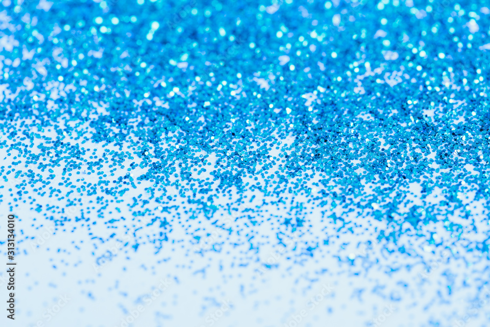 Obraz premium Blue shiny glitter on a white background, copy space