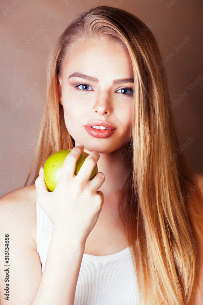 young pretty blond woman holding green apple smiling slim, lifestyle people concept young pretty blond woman holding green apple smiling slim, lifestyle people concept