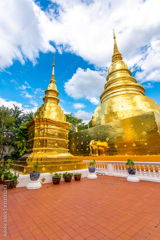 Fototapeta premium Beautiful view of Wat Phra Singh temple with golden chedi stupa and pagoda in Chiang Mai city, Thailand. Symbol of buddhism and ancient spirituality. Famous tourist destination. Summer weather