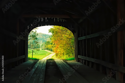 Inside of a covered bridge leading to an old country road. New England covered bridge