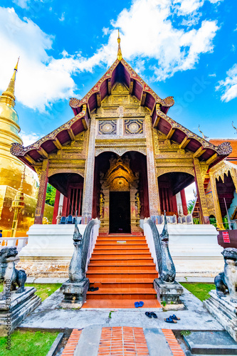 Wat Phra Singh temple in Chiang Mai city, Thailand. Wooden building is ancient place of buddhist spirituality in northen Thailand. Near is golden chedi stupa and pagoda. Famous tourist destination © Martin