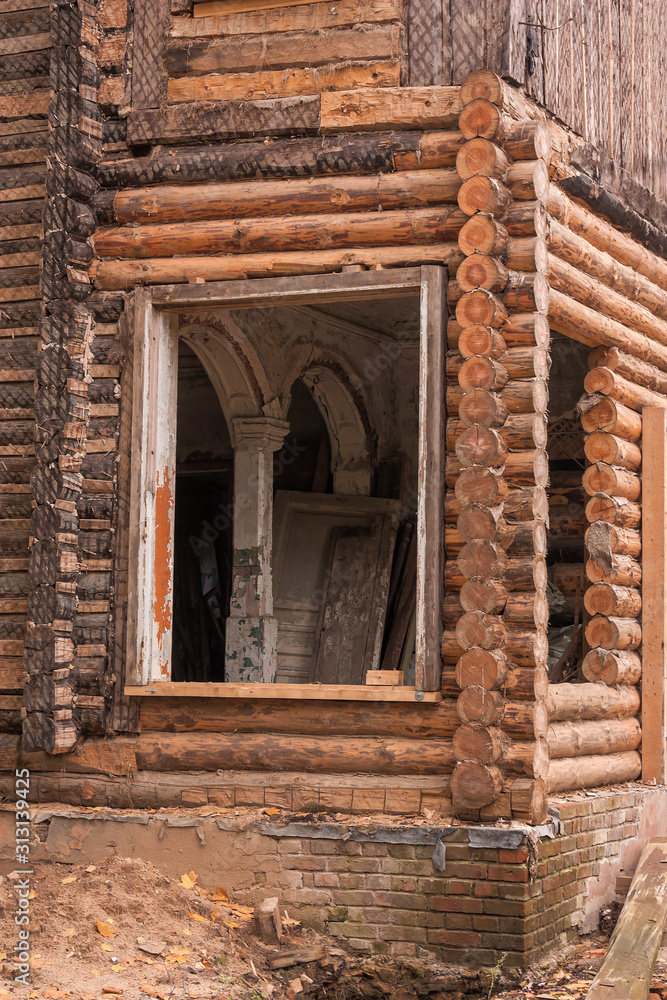 Old residential wooden houses. Windows and walls with damaged old roof with weathered paint. To close. On the street in the Arkhangelsk region of Russia.