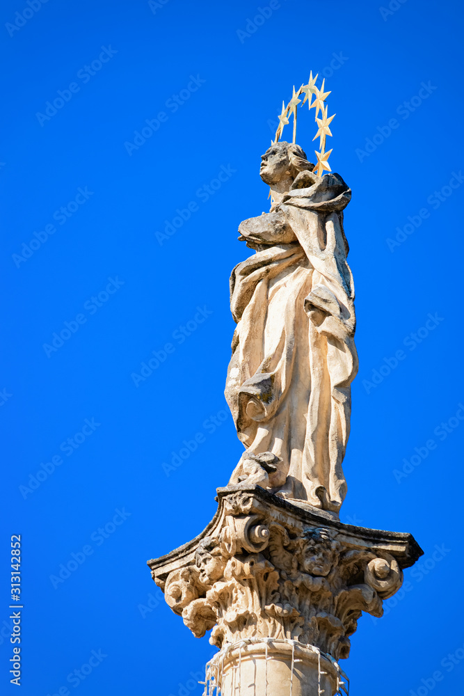 Plague Column in small spa town on thermal springs Bad Radkersburg in Styria in Austria. Blue sky on the background