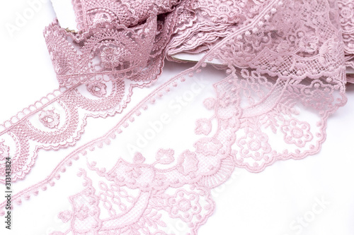 Lace delicate pink powdery colors. wound on a reel on a white background. sewing.