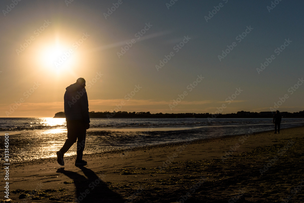 Person silhouette walking on the beach during morning in Puerto Madryn, Patagonia, Argentina