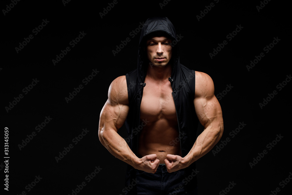 Fototapeta premium Muscular bodybuilder with jar of protein on a dark background. Sports nutrition. Bodybuilding nutrition supplements, sport, workout, healthy lifestyle concept.
