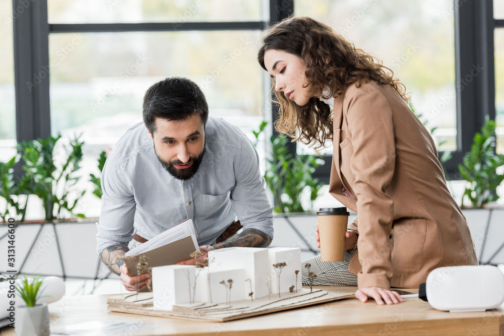 Fototapeta premium virtual reality architects looking at model of house in office
