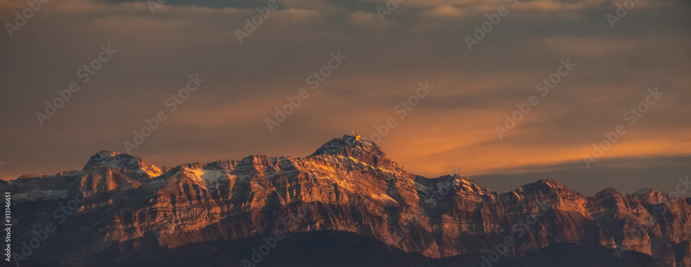 Sunset on mount saentis in switzerland with clouds and peak station in alps