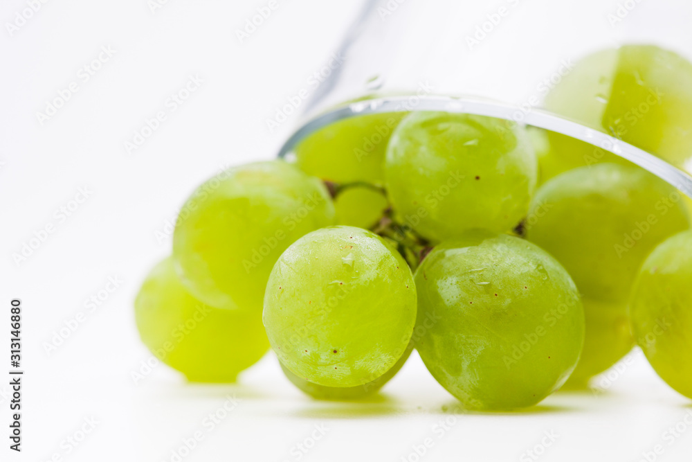 Fresh green grapes with glass cup isolated Fresh green grapes with glass cup isolated