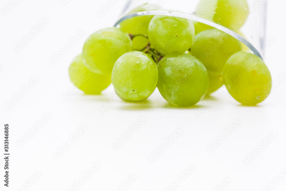 Fresh green grapes with glass cup isolated Fresh green grapes with glass cup isolated