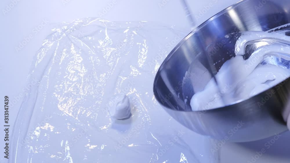 Scooping ointment with a spatula on transparent foil in the pharmacy laboratory Scooping ointment with a spatula on transparent foil in the pharmacy laboratory