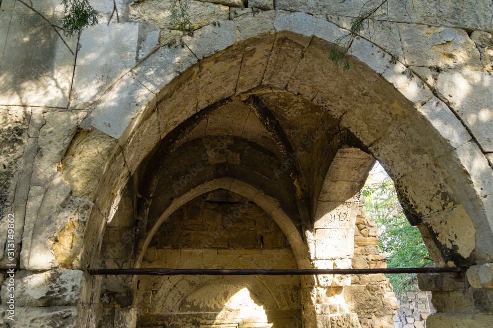 Feodosia, Crimea, Russia - September 26, 2019: Ancient stone arch at  entrance to medieval Armenian church of St. Sergius (Surb Sarkis) - in Feodosia.
