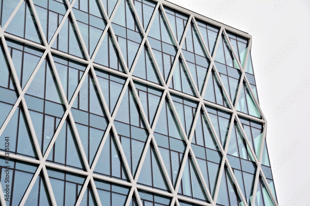 Fototapeta premium Abstract image of looking up at modern glass and concrete building. Architectural exterior detail of office building. 