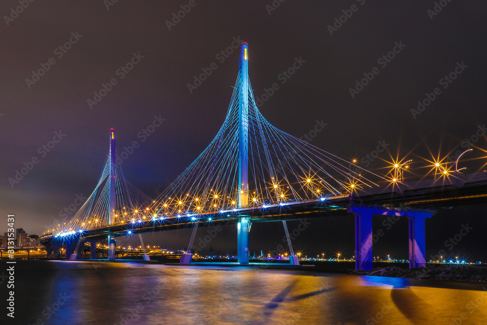 Obraz premium The bridge of circle highway road over Neva river near the mouth of it in the night. Night view on the buildings of Petersburg city and the Finish gulf