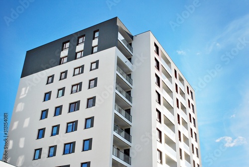 Modern apartment buildings on a sunny day with a blue sky. Facade of a modern apartment building. © Grand Warszawski
