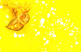 Golden carnival or theatrical mask on yellow background with sparkles. Festive concept. Close-up